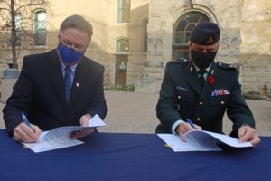 two men signing papers at a table