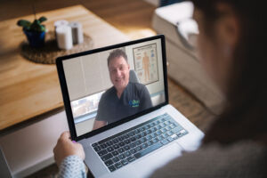 A patient meets with a QDoc doctor virtually, via a laptop.